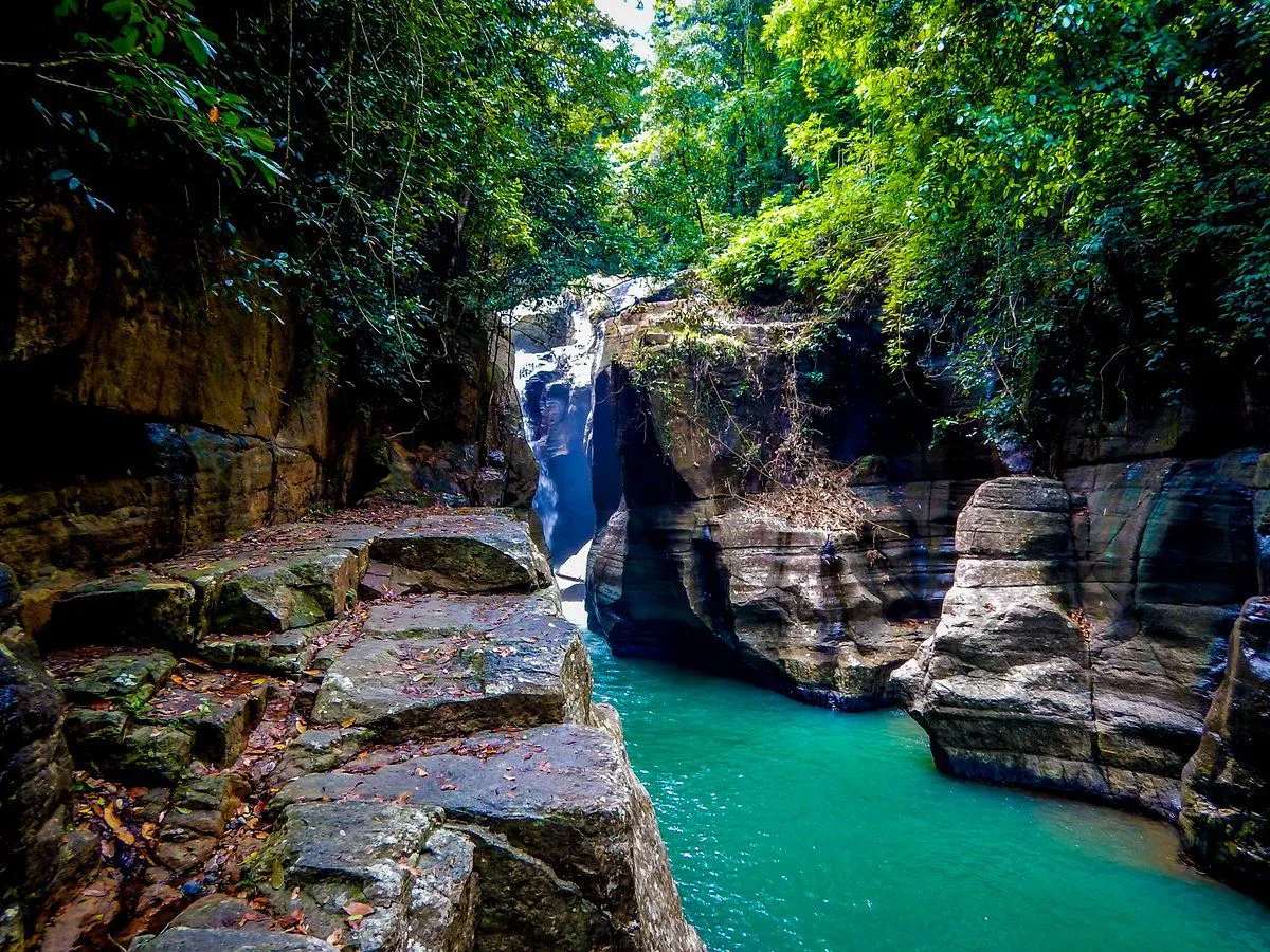 The turquoise river of Cunca Wulang canyon between steep rock walls